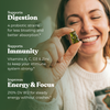 Optimal Human - Superfood Greens Gummies (30 Day Supply) — Smiling brunette woman about to eat a green gummy bear, dark green benefits overlay reads 'Supports Digestion, Supports Immunity, Improves Energy & Focus' with probiotic, vitamin and 210% DV B12 callouts