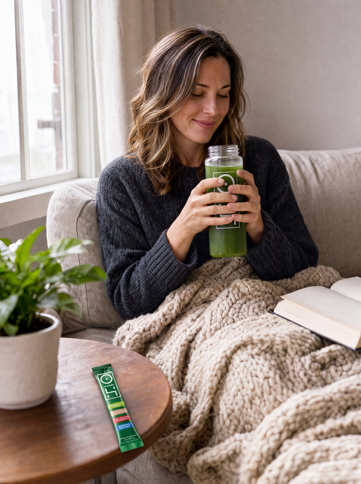 A woman relaxing on her sofa with a bottle of Superfood Greens