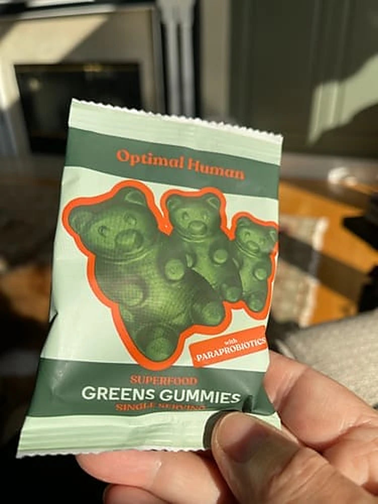 A customer photo of a single-serve greens gummies sachet held in one hand