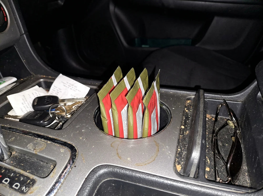 Superfood Greens Gummies packs tucked in a car cup holder