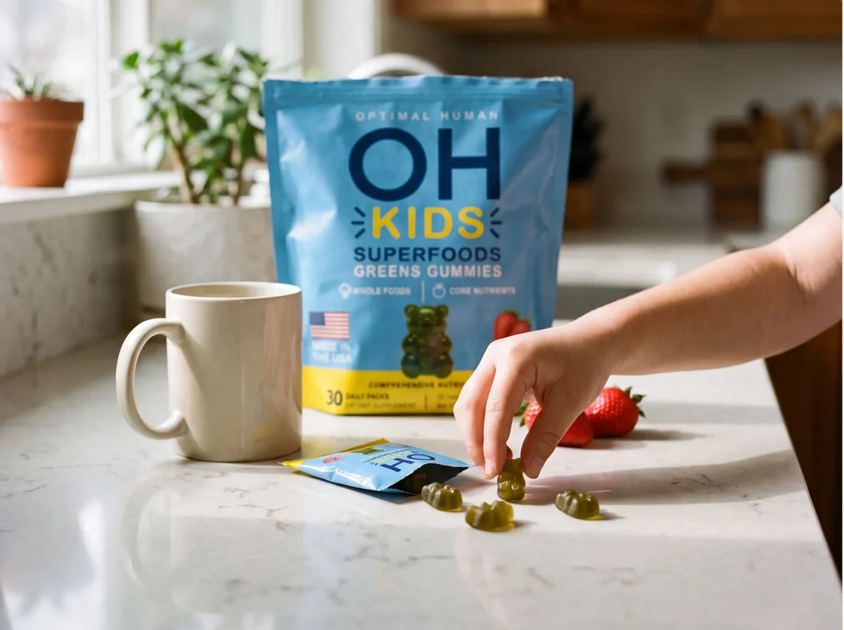 A child reaching for green gummies on the kitchen counter next to an OH Kids pack